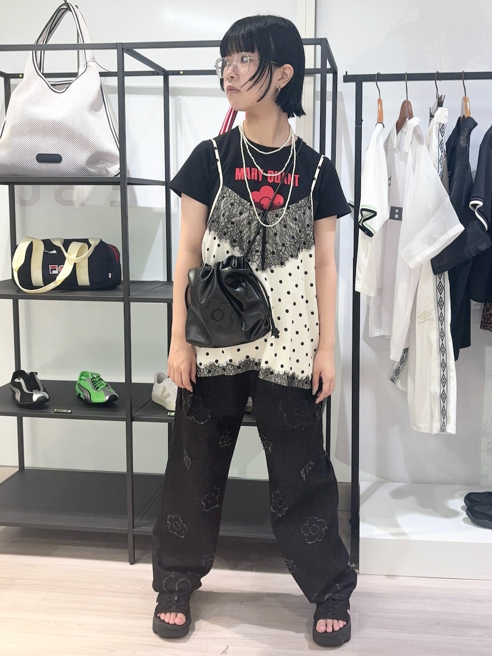 ホワイト系のキャミソール、ブラック系のサンダル、ブラック系のデニムパンツを着用したレディースの夏コーディネートの2枚目の写真