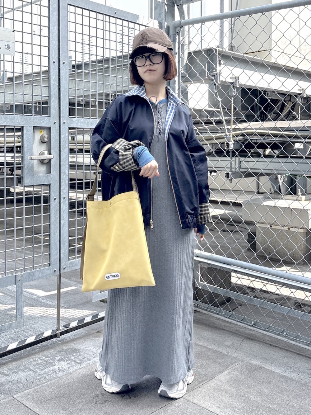 グレー系のワンピース、ブルー系のブルゾン、ホワイト系のスニーカーを着用したレディースの春コーディネートの4枚目の写真