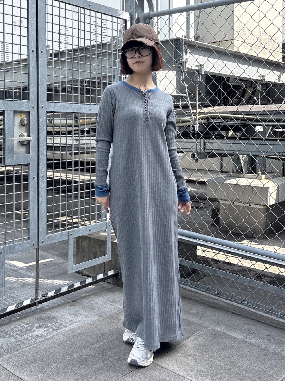 グレー系のワンピース、ブルー系のブルゾン、ホワイト系のスニーカーを着用したレディースの春コーディネートの5枚目の写真