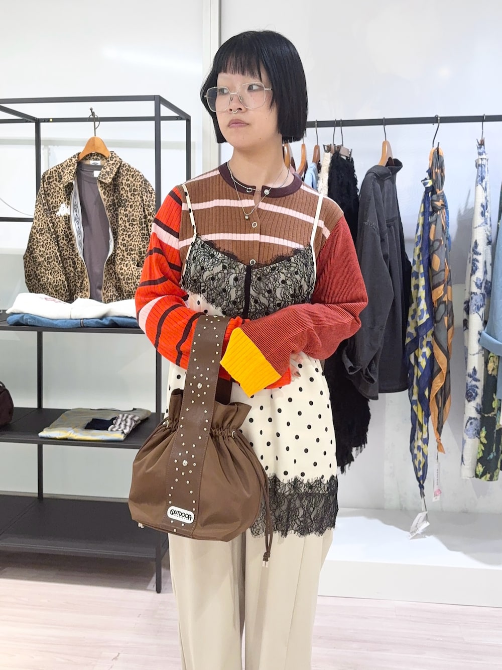 ブラウン系のニット/セーター、ブラウン系のショルダーバッグ、ベージュ系のその他パンツを着用したレディースの秋コーディネートの5枚目の写真