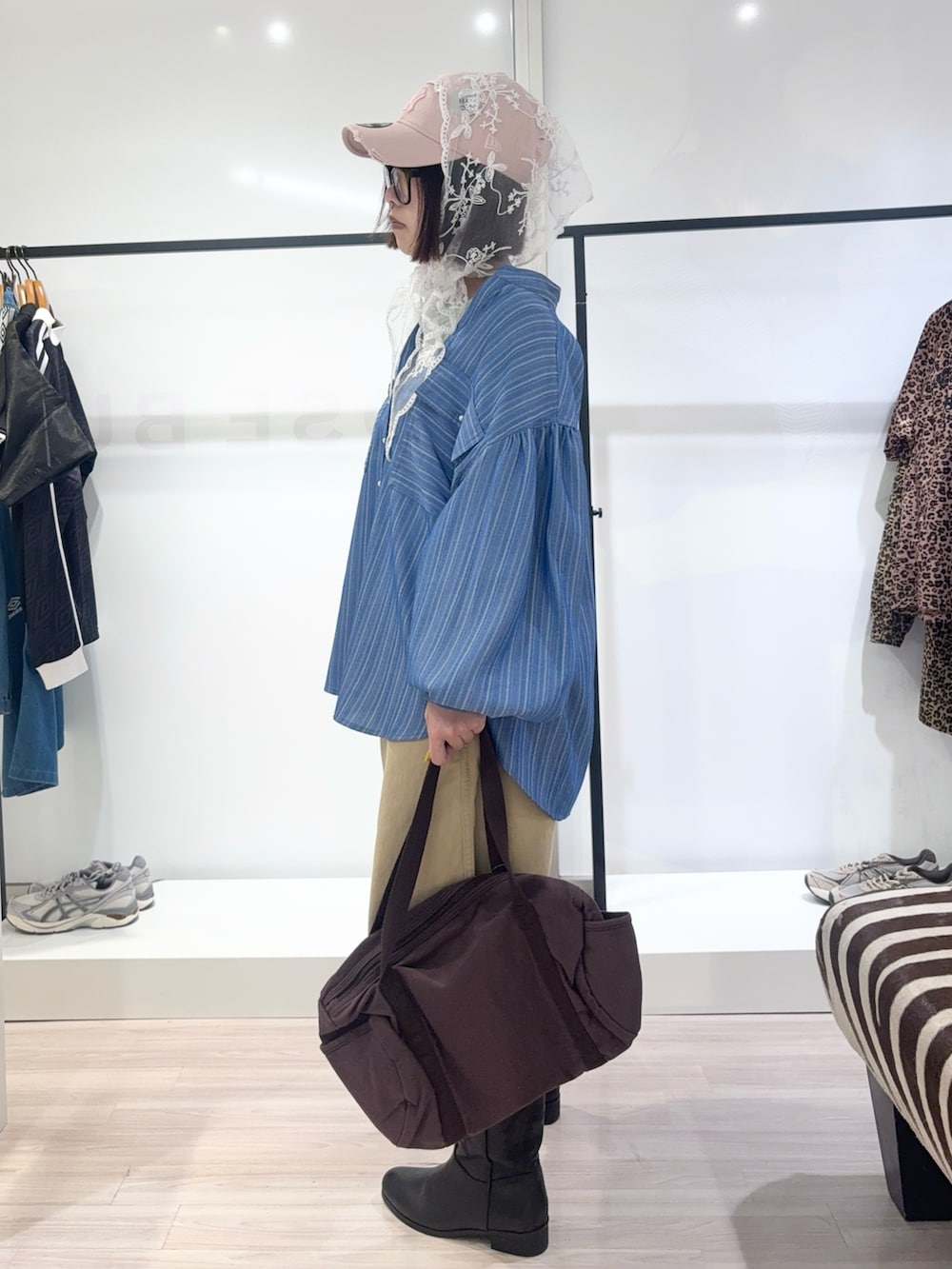 ブルー系のシャツ/ブラウス、ブラック系のブーツ、グリーン系のTシャツ/カットソーを着用したレディースの春コーディネートの3枚目の写真