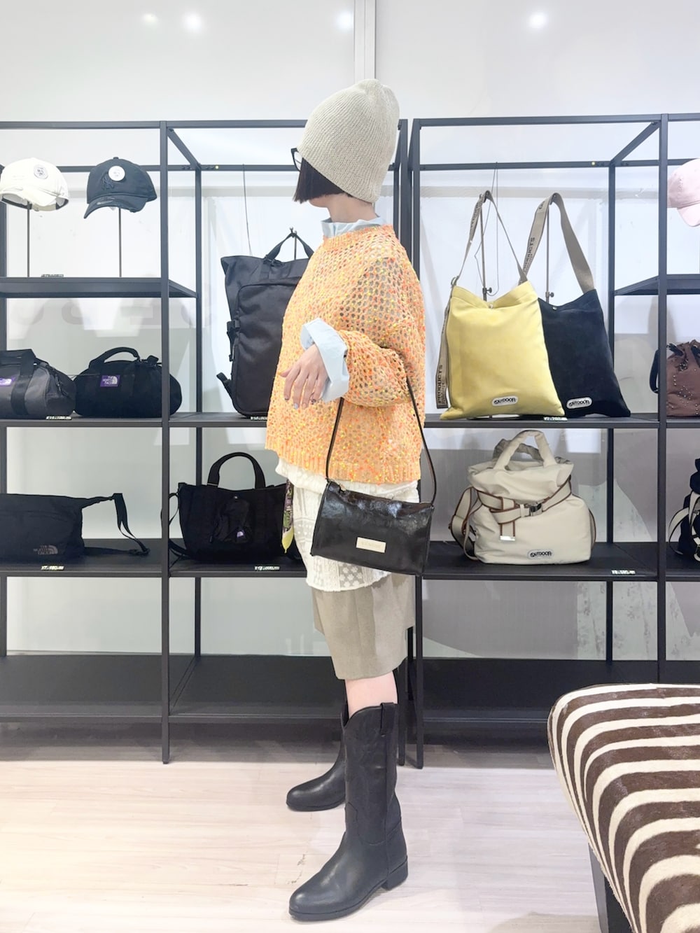 ブルー系のブルゾン、オレンジ系のニット/セーター、ホワイト系のワンピースを着用したレディースの春コーディネートの4枚目の写真