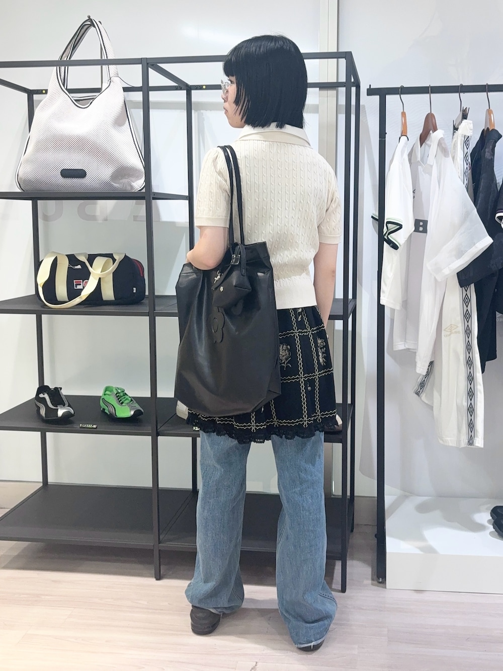 ブルー系のデニムパンツ、ブラック系のサンダル、ブラック系のカーディガン/ボレロを着用したレディースの夏コーディネートの4枚目の写真
