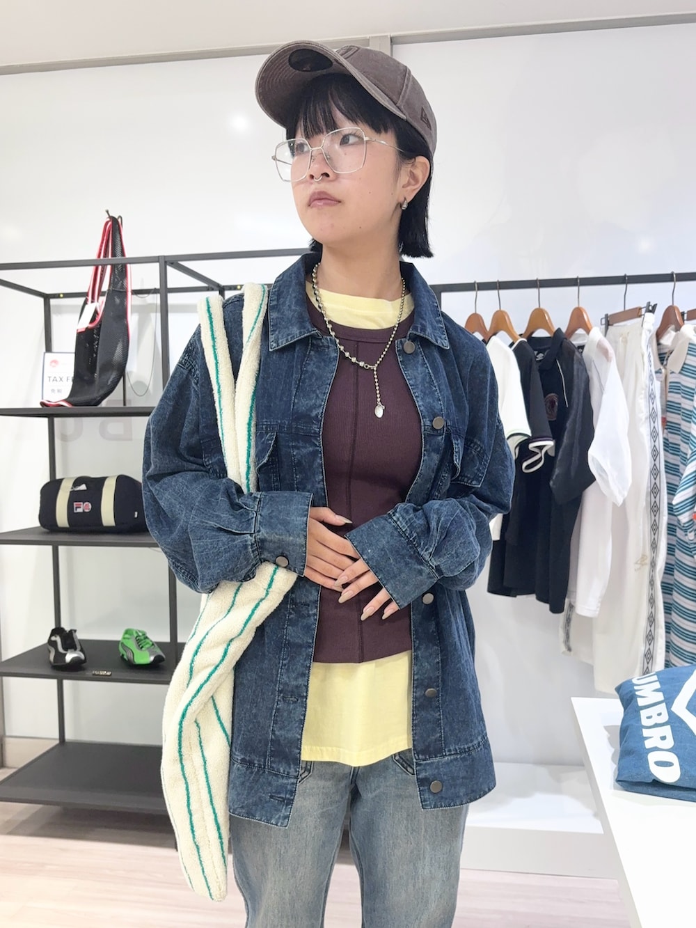 ブルー系のデニムパンツ、ブラック系のサンダル、イエロー系のTシャツ/カットソーを着用したレディースの夏コーディネートの5枚目の写真