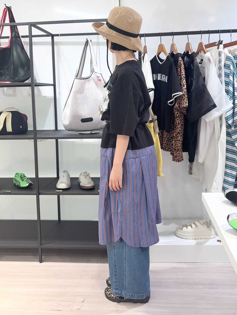 ブルー系のデニムパンツ、ブラック系のスニーカー、イエロー系のトートバッグを着用したレディースの夏コーディネートの3枚目の写真