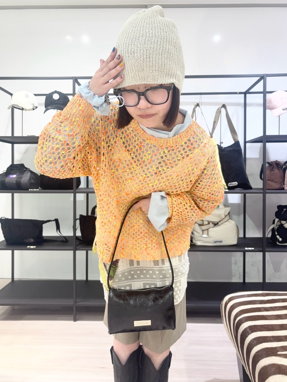 ブルー系のブルゾン、オレンジ系のニット/セーター、ホワイト系のワンピースを着用したレディースの春コーディネートの6枚目の写真