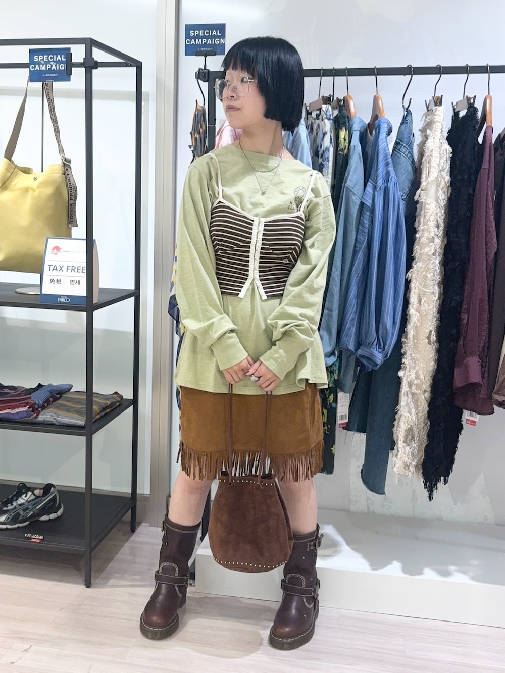 グリーン系のTシャツ/カットソー、ブラウン系のショルダーバッグ、ブラウン系のキャミソールを着用したレディースの秋コーディネートの2枚目の写真