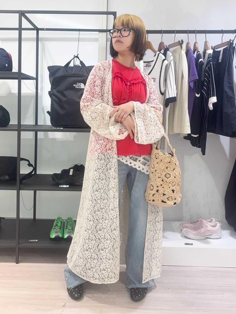 ホワイト系のワンピース、ブルー系のデニムパンツ、ベージュ系のショルダーバッグを着用したレディースの春コーディネートの2枚目の写真