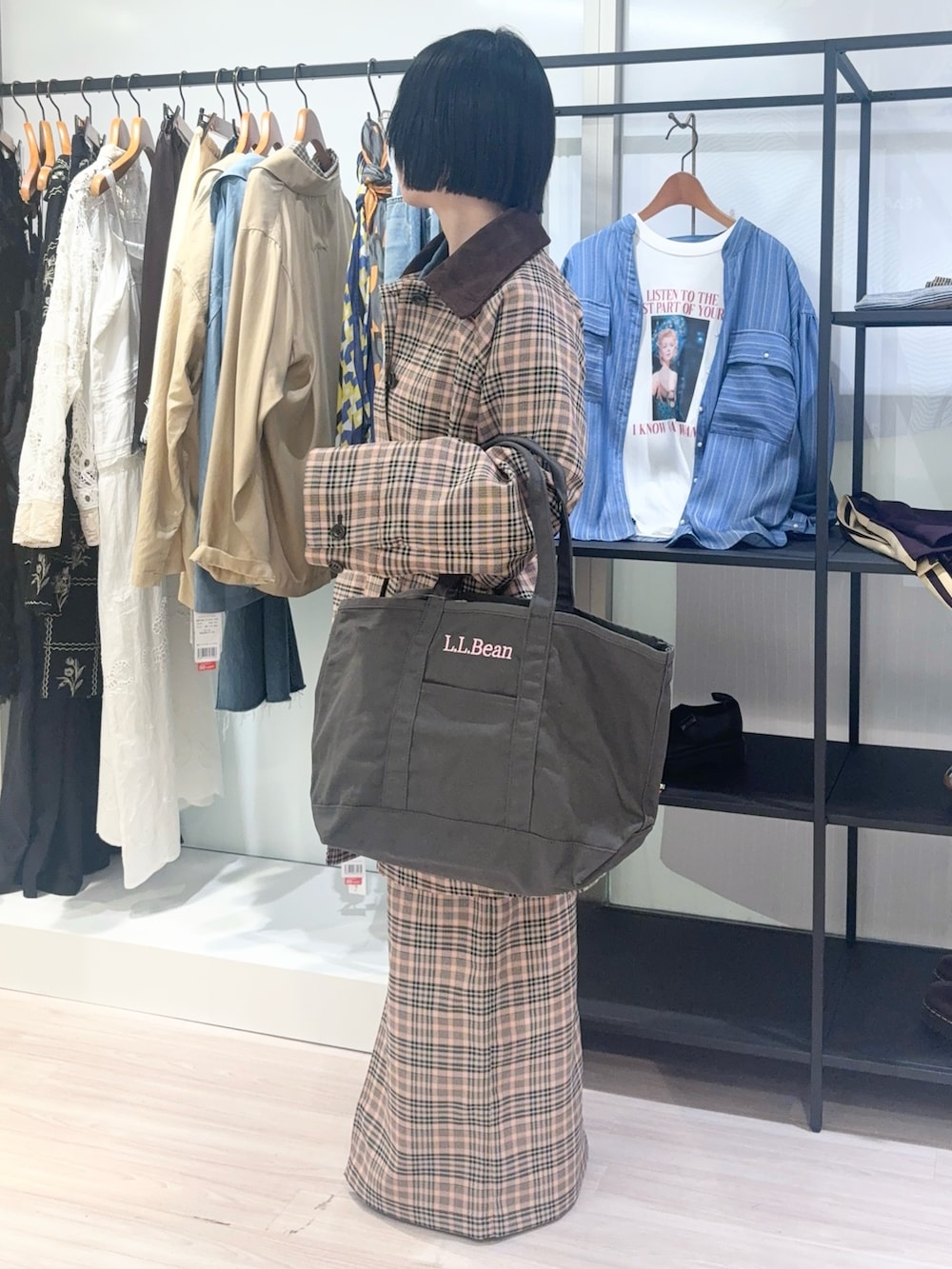 イエロー系のニット/セーター、オレンジ系のステンカラーコート、ブラック系のスニーカーを着用したレディースの秋コーディネートの3枚目の写真