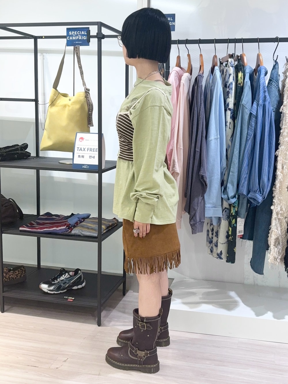 グリーン系のTシャツ/カットソー、ブラウン系のショルダーバッグ、ブラウン系のキャミソールを着用したレディースの秋コーディネートの3枚目の写真