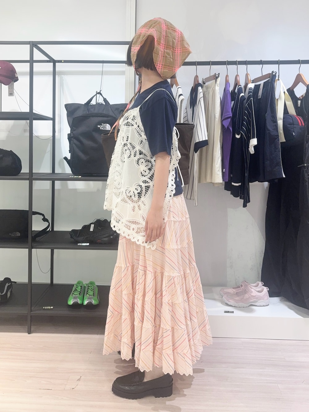 ブラウン系のトートバッグ、ホワイト系のキャミソール、ブルー系のTシャツ/カットソーを着用したレディースの春コーディネートの3枚目の写真