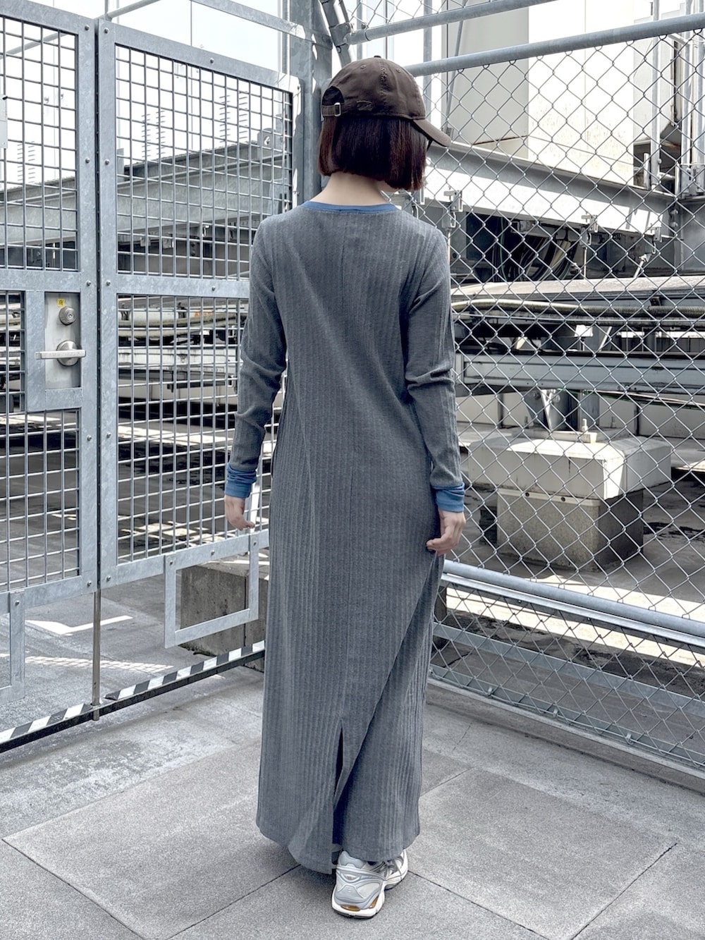 グレー系のワンピース、ブルー系のブルゾン、ホワイト系のスニーカーを着用したレディースの春コーディネートの6枚目の写真