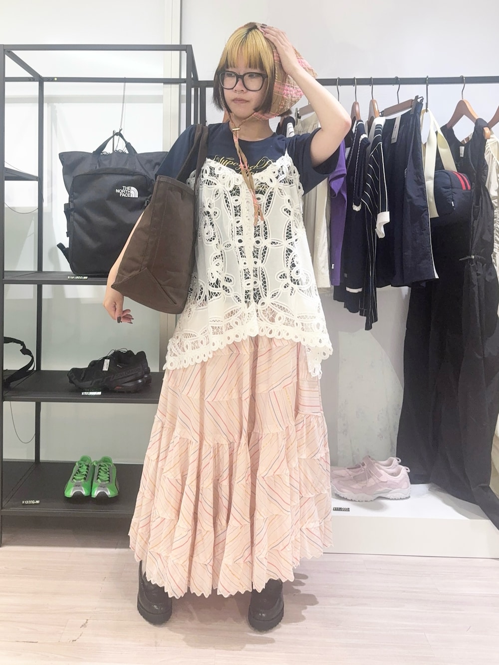 ブラウン系のトートバッグ、ホワイト系のキャミソール、ブルー系のTシャツ/カットソーを着用したレディースの春コーディネートの2枚目の写真