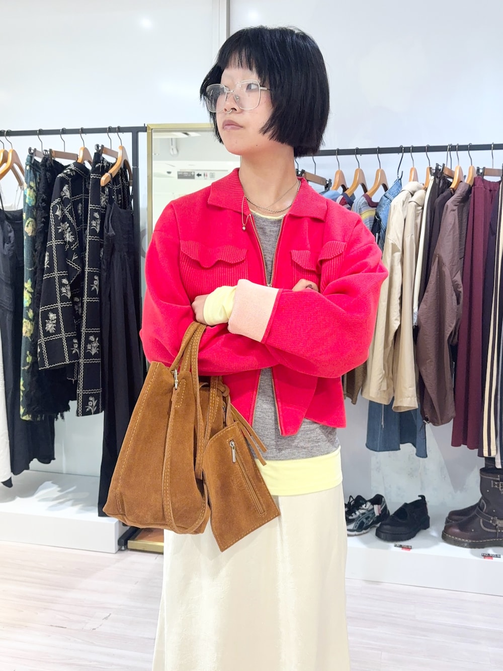 グレー系のTシャツ/カットソー、ホワイト系のスカート、レッド系のカーディガン/ボレロを着用したレディースの秋コーディネートの5枚目の写真