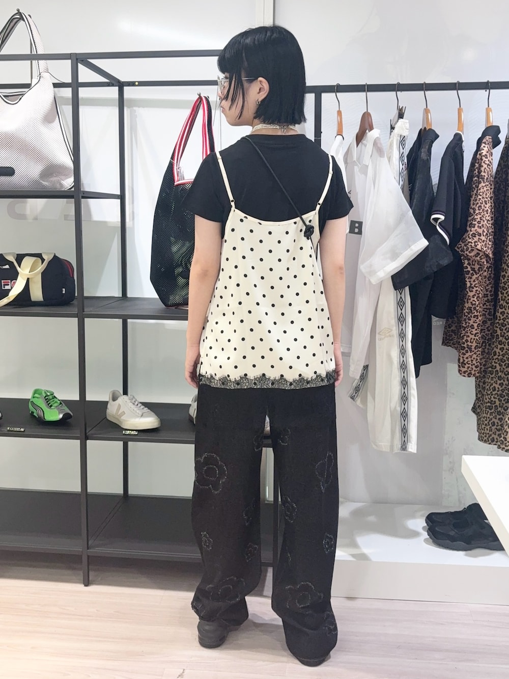ホワイト系のキャミソール、ブラック系のサンダル、ブラック系のデニムパンツを着用したレディースの夏コーディネートの4枚目の写真