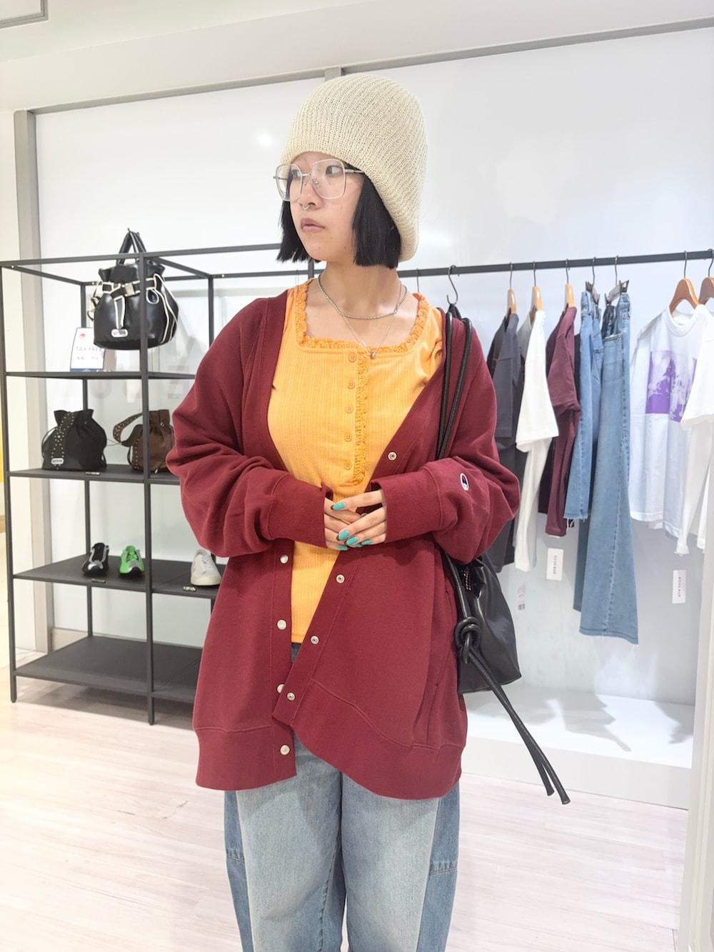 ブラック系のその他シューズ、オレンジ系のTシャツ/カットソー、レッド系のスウェットを着用したレディースの秋コーディネートの5枚目の写真