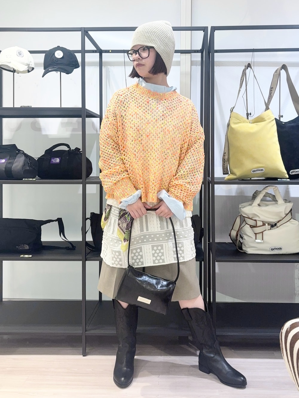 ブルー系のブルゾン、オレンジ系のニット/セーター、ホワイト系のワンピースを着用したレディースの春コーディネートの3枚目の写真