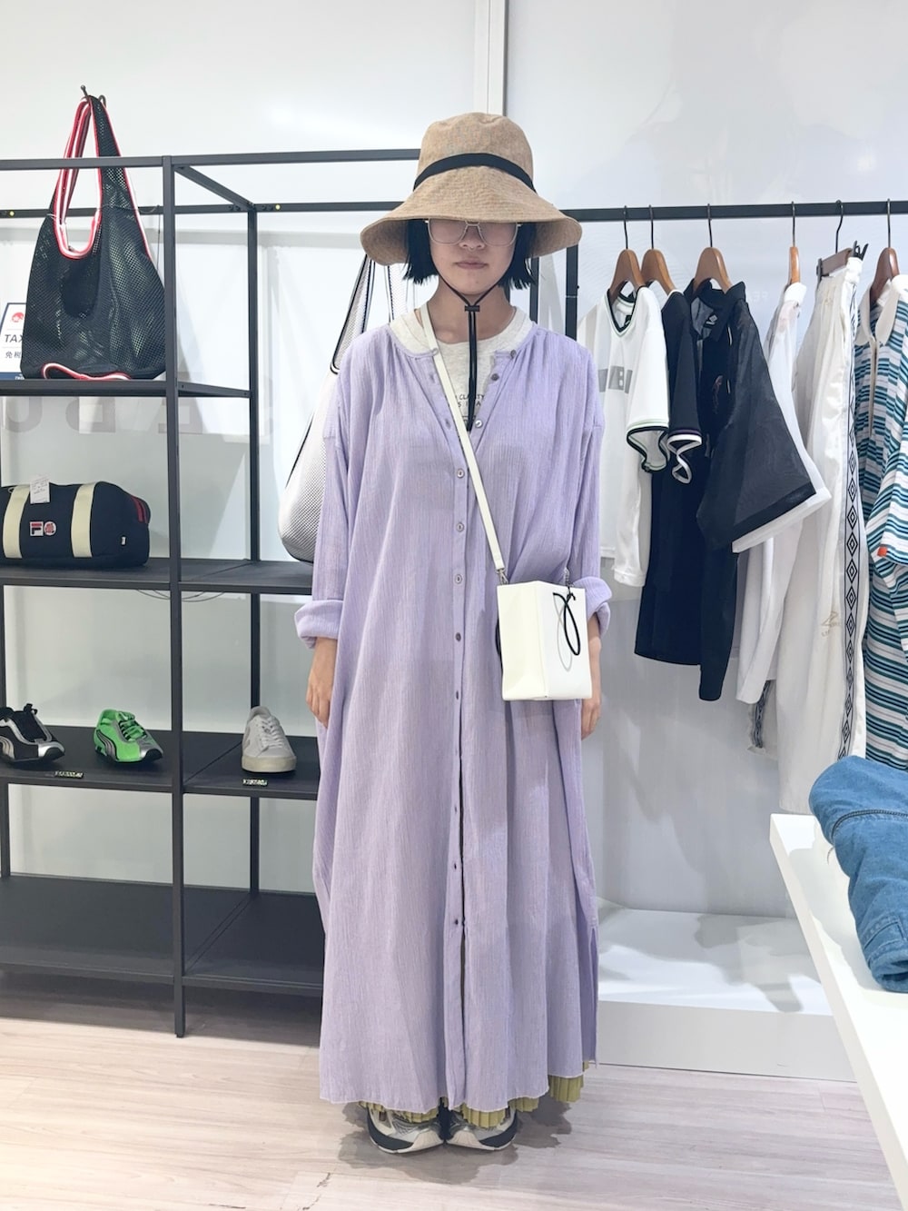 ホワイト系のショルダーバッグ、ベージュ系のTシャツ/カットソー、イエロー系のスカートを着用したレディースの夏コーディネートの2枚目の写真