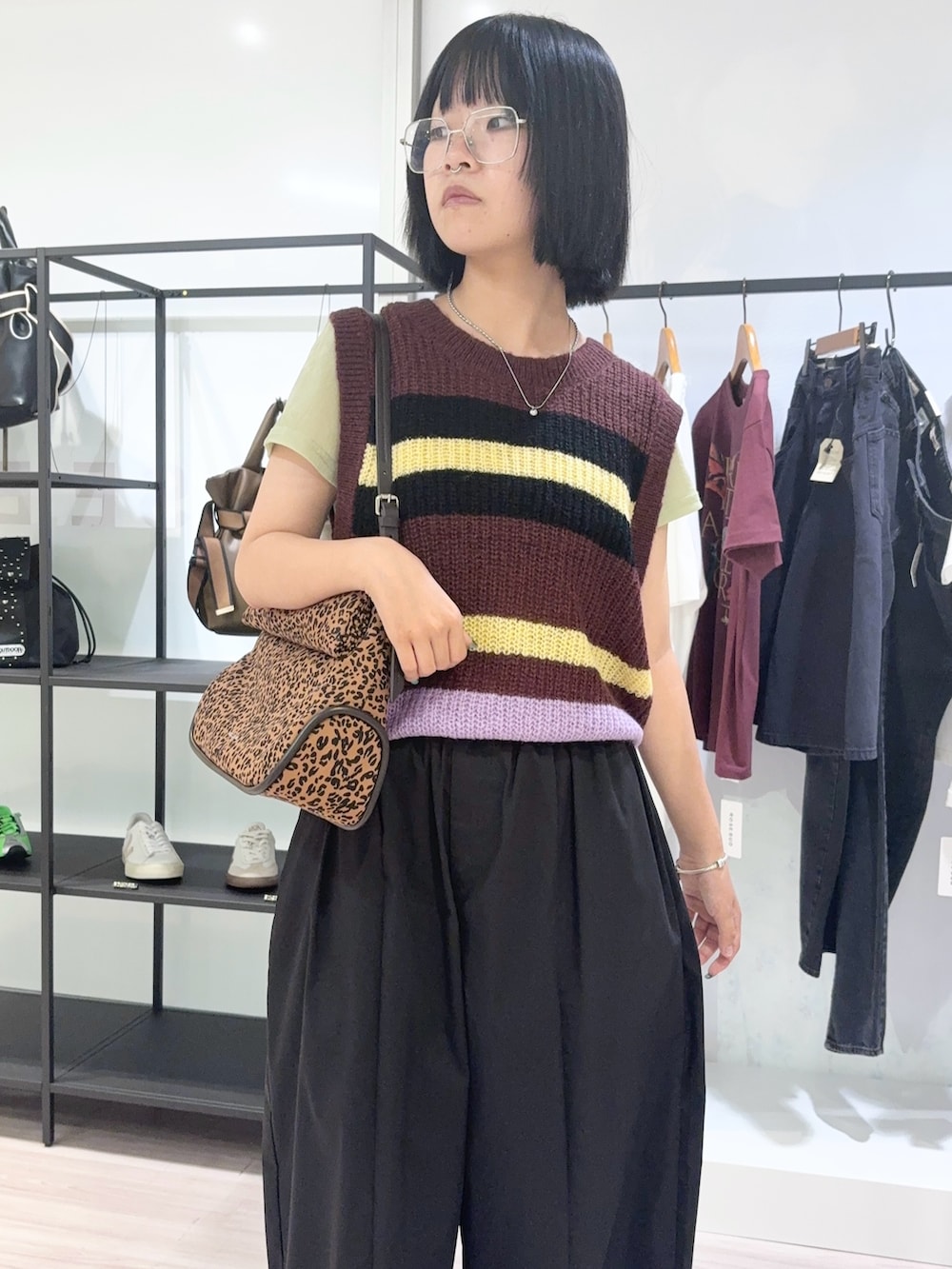 グリーン系のTシャツ/カットソー、ブラウン系のベスト、ブラック系のその他パンツを着用したレディースの秋コーディネートの5枚目の写真