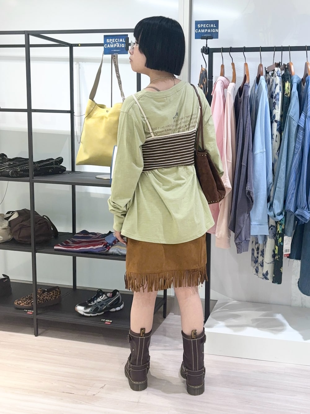 グリーン系のTシャツ/カットソー、ブラウン系のショルダーバッグ、ブラウン系のキャミソールを着用したレディースの秋コーディネートの4枚目の写真