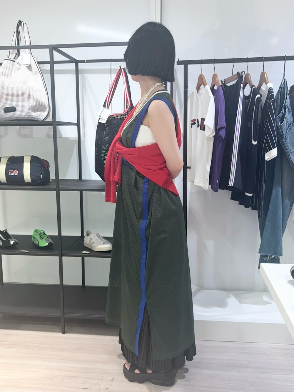 レッド系のニット/セーター、レッド系のショルダーバッグ、ブラック系のサンダルを着用したレディースの夏コーディネートの2枚目の写真
