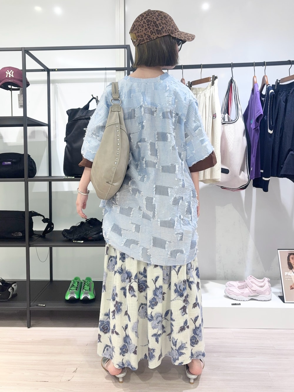 ブラウン系のTシャツ/カットソー、ホワイト系のスカート、ブラウン系のキャップを着用したレディースの春コーディネートの4枚目の写真
