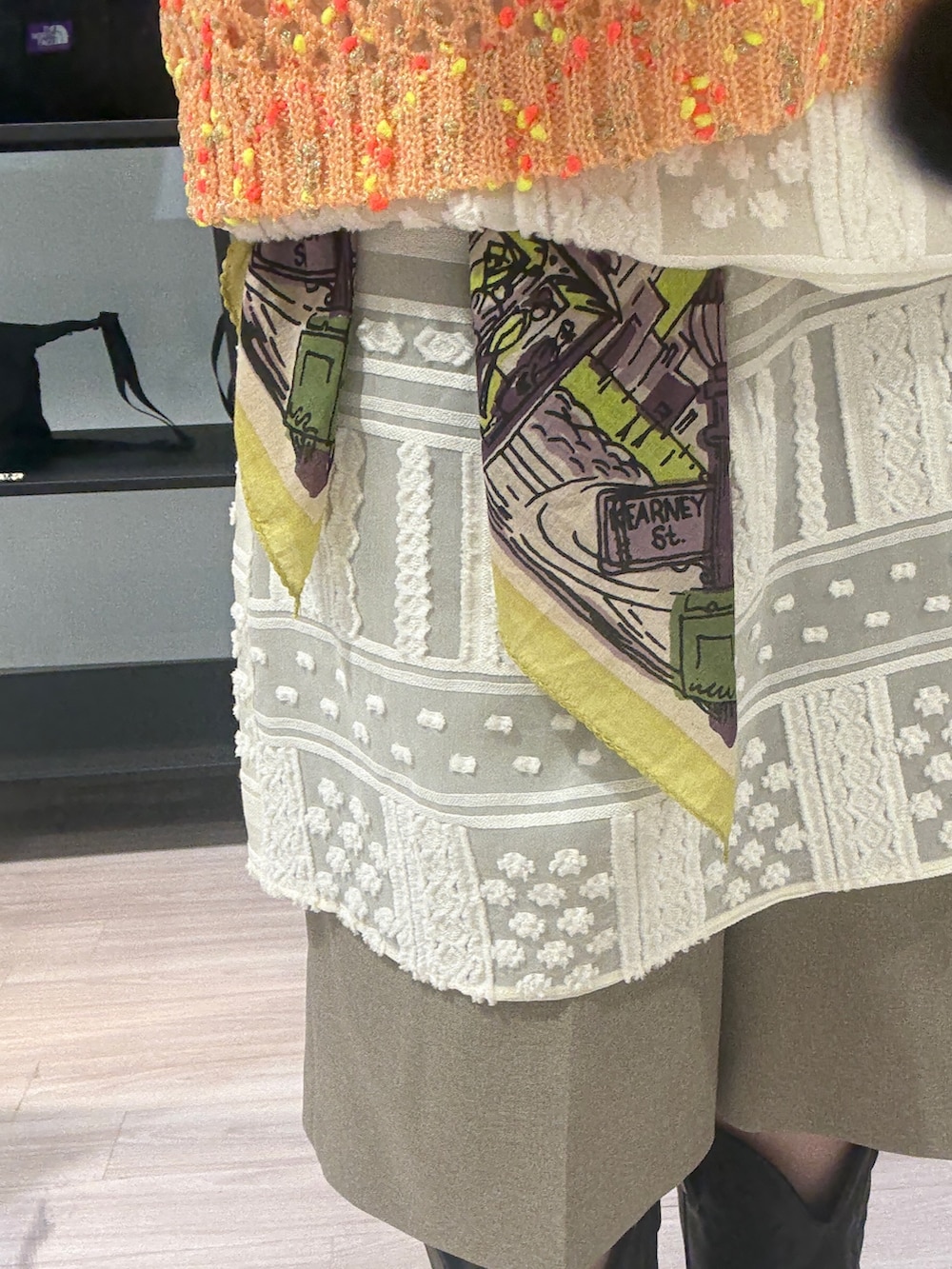 ブルー系のブルゾン、オレンジ系のニット/セーター、ホワイト系のワンピースを着用したレディースの春コーディネートの7枚目の写真