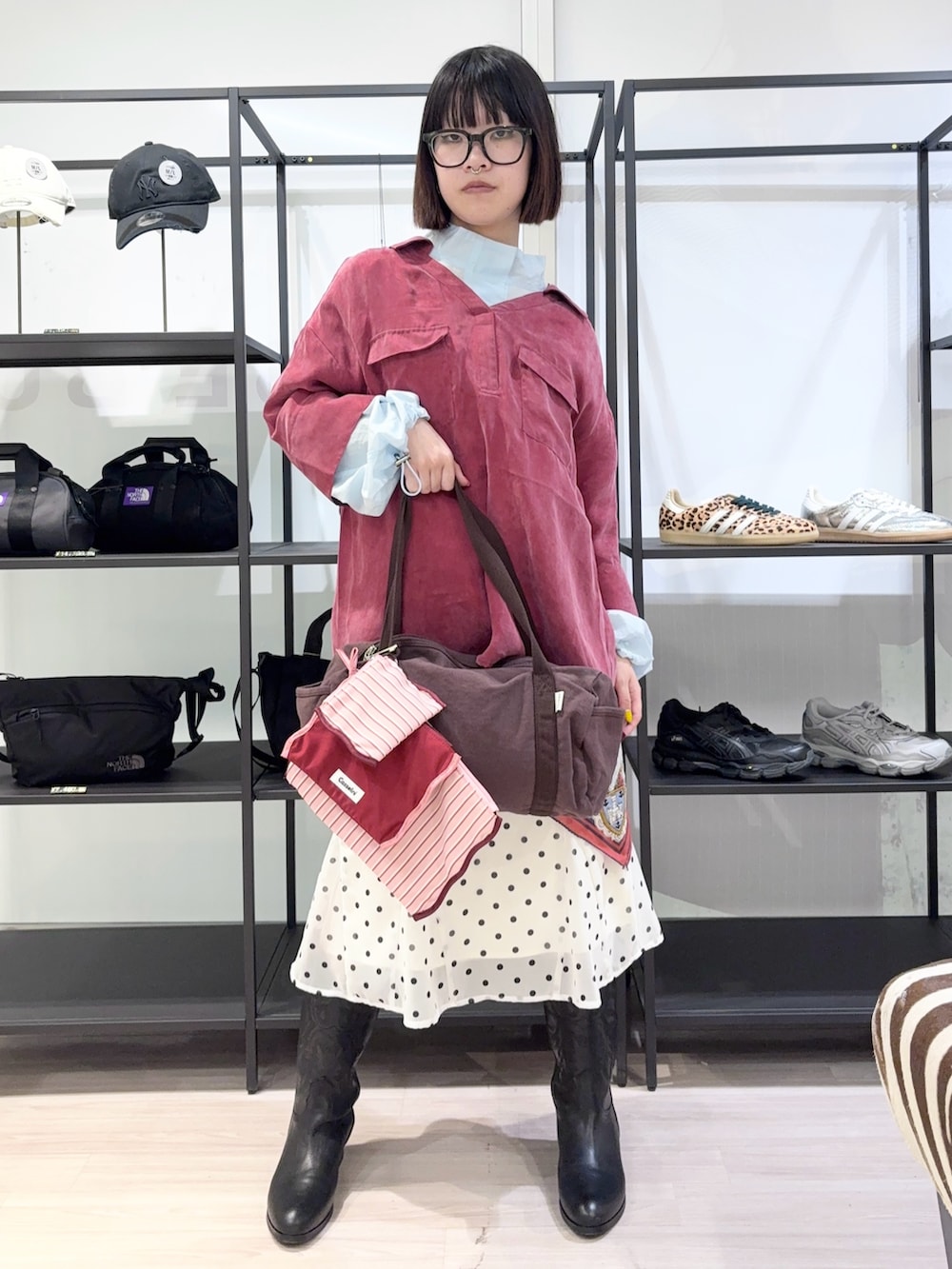 ブルー系のブルゾン、ブラウン系のボストンバッグ、ブラック系のブーツを着用したレディースの春コーディネートの2枚目の写真