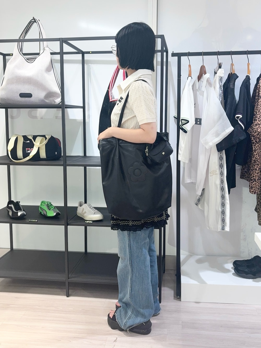 ブルー系のデニムパンツ、ブラック系のサンダル、ブラック系のカーディガン/ボレロを着用したレディースの夏コーディネートの3枚目の写真