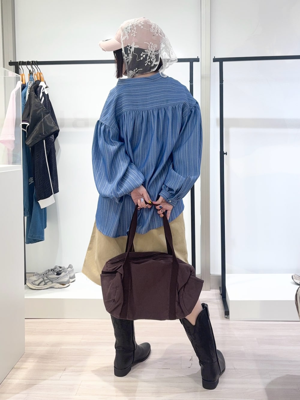 ブルー系のシャツ/ブラウス、ブラック系のブーツ、グリーン系のTシャツ/カットソーを着用したレディースの春コーディネートの4枚目の写真