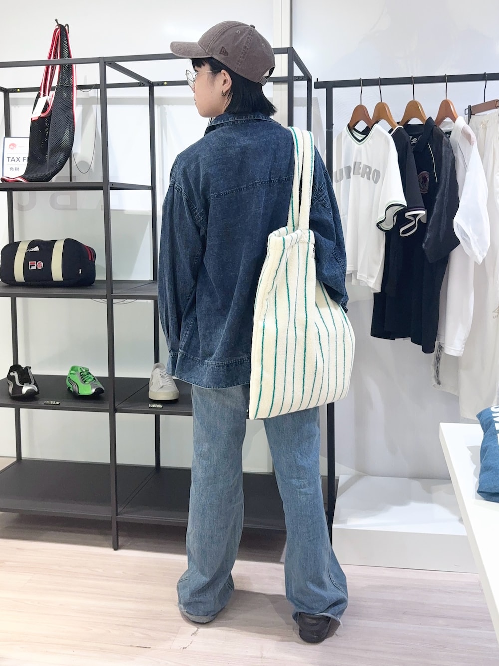 ブルー系のデニムパンツ、ブラック系のサンダル、イエロー系のTシャツ/カットソーを着用したレディースの夏コーディネートの4枚目の写真
