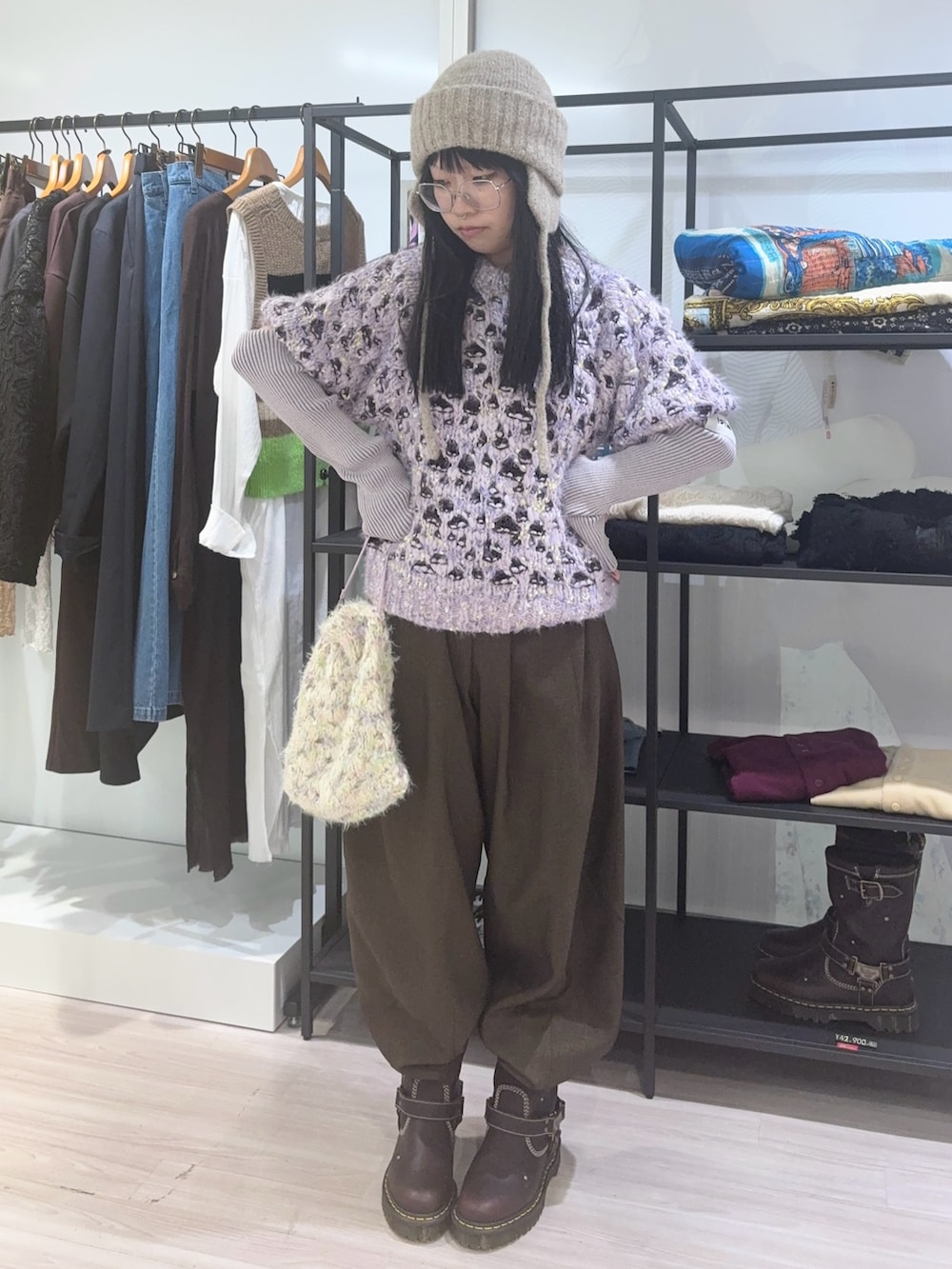 パープル系のニット/セーター、ホワイト系のショルダーバッグ、ベージュ系のニットキャップ/ビーニーを着用したレディースの秋コーディネートの2枚目の写真