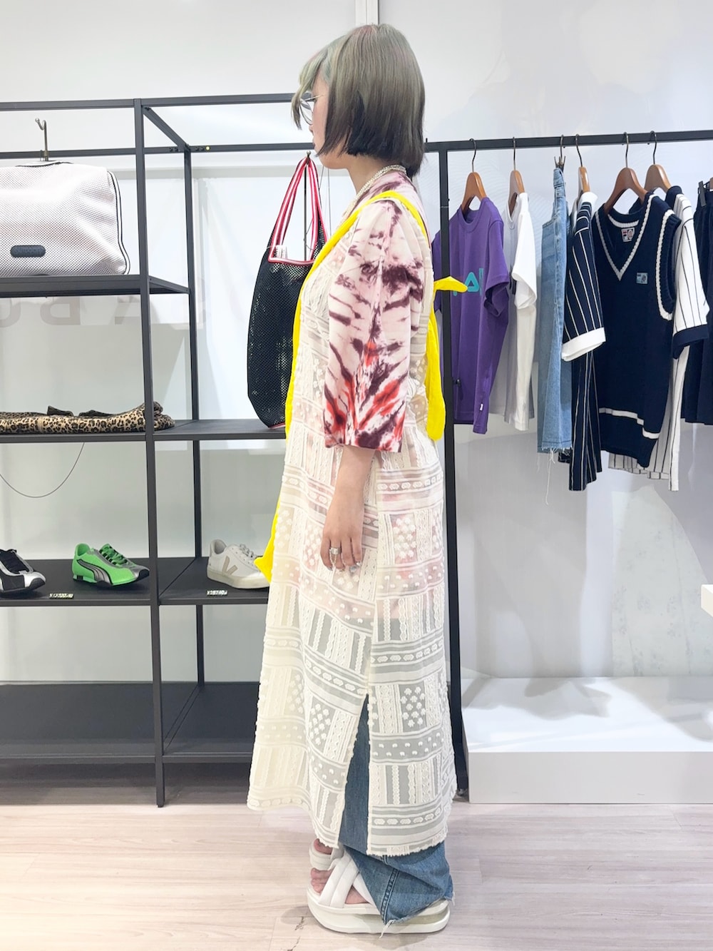 レッド系のTシャツ/カットソー、ホワイト系のワンピース、ブルー系のデニムパンツを着用したレディースの夏コーディネートの3枚目の写真