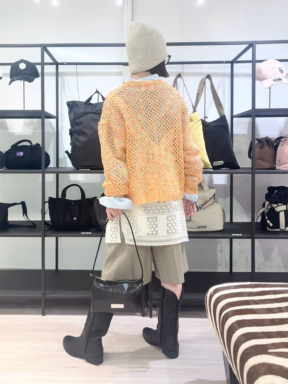 ブルー系のブルゾン、オレンジ系のニット/セーター、ホワイト系のワンピースを着用したレディースの春コーディネートの5枚目の写真