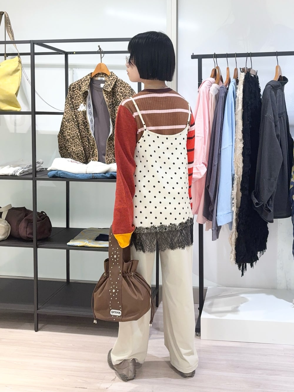 ブラウン系のニット/セーター、ブラウン系のショルダーバッグ、ベージュ系のその他パンツを着用したレディースの秋コーディネートの4枚目の写真