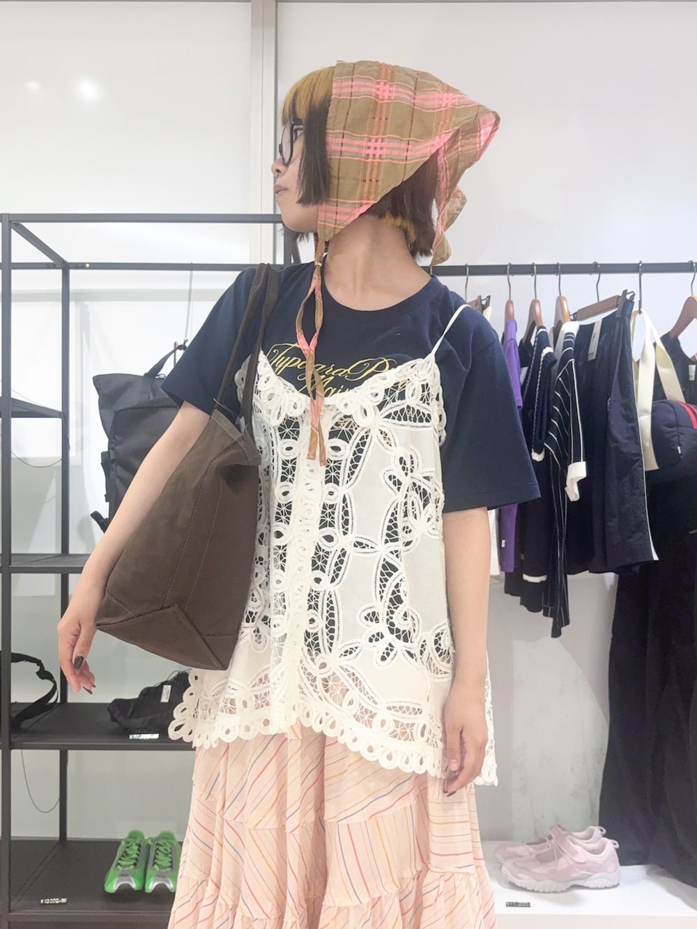ブラウン系のトートバッグ、ホワイト系のキャミソール、ブルー系のTシャツ/カットソーを着用したレディースの春コーディネートの5枚目の写真