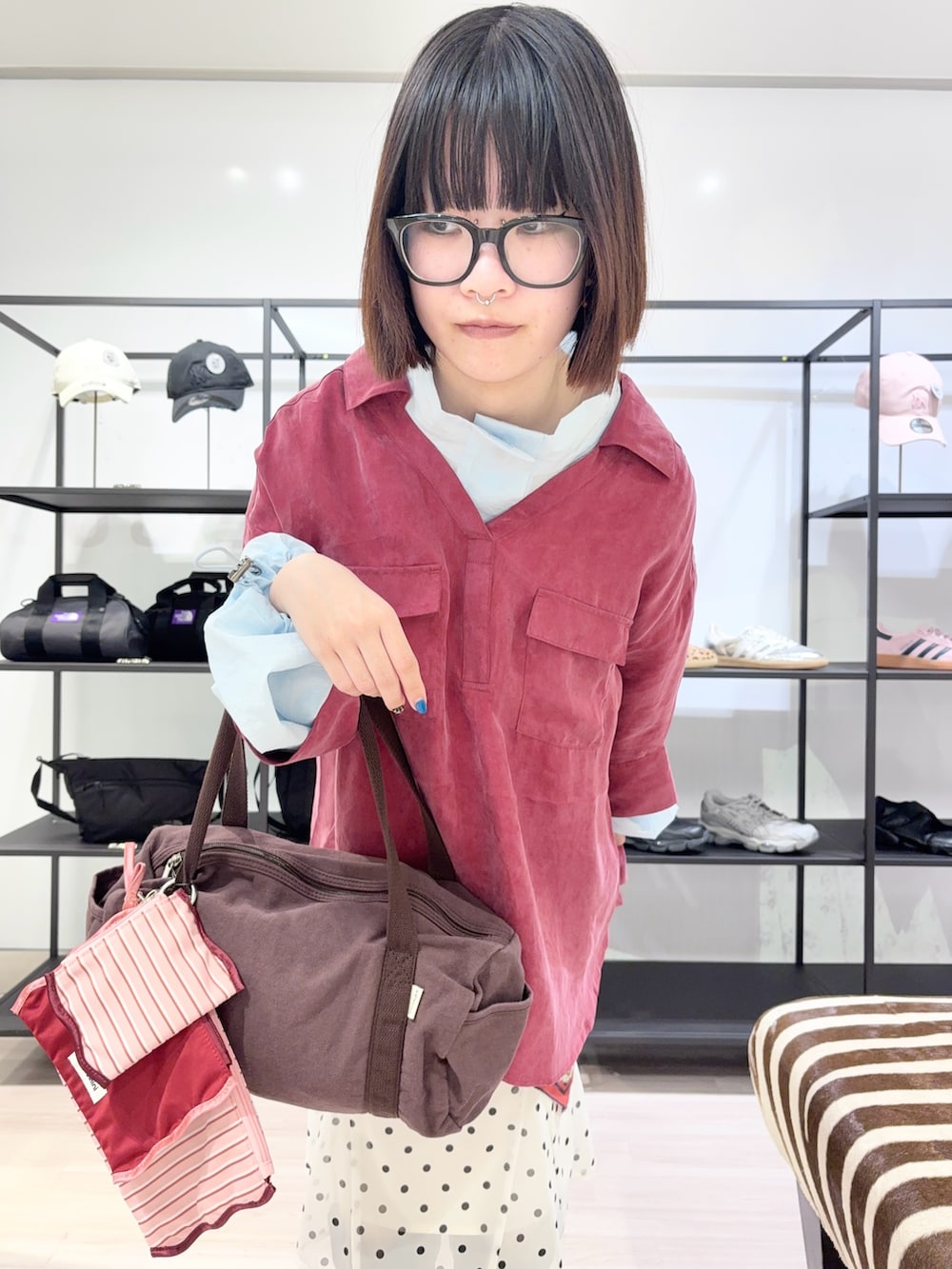 ブルー系のブルゾン、ブラウン系のボストンバッグ、ブラック系のブーツを着用したレディースの春コーディネートの5枚目の写真