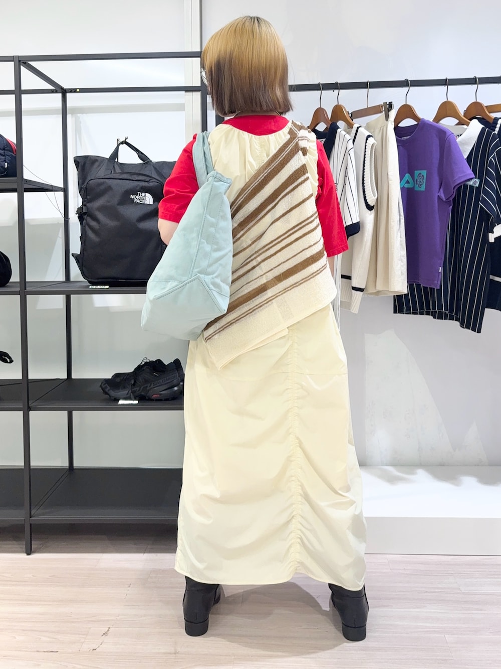 ブラック系のブーツ、ホワイト系のカーディガン/ボレロ、レッド系のTシャツ/カットソーを着用したレディースの夏コーディネートの4枚目の写真