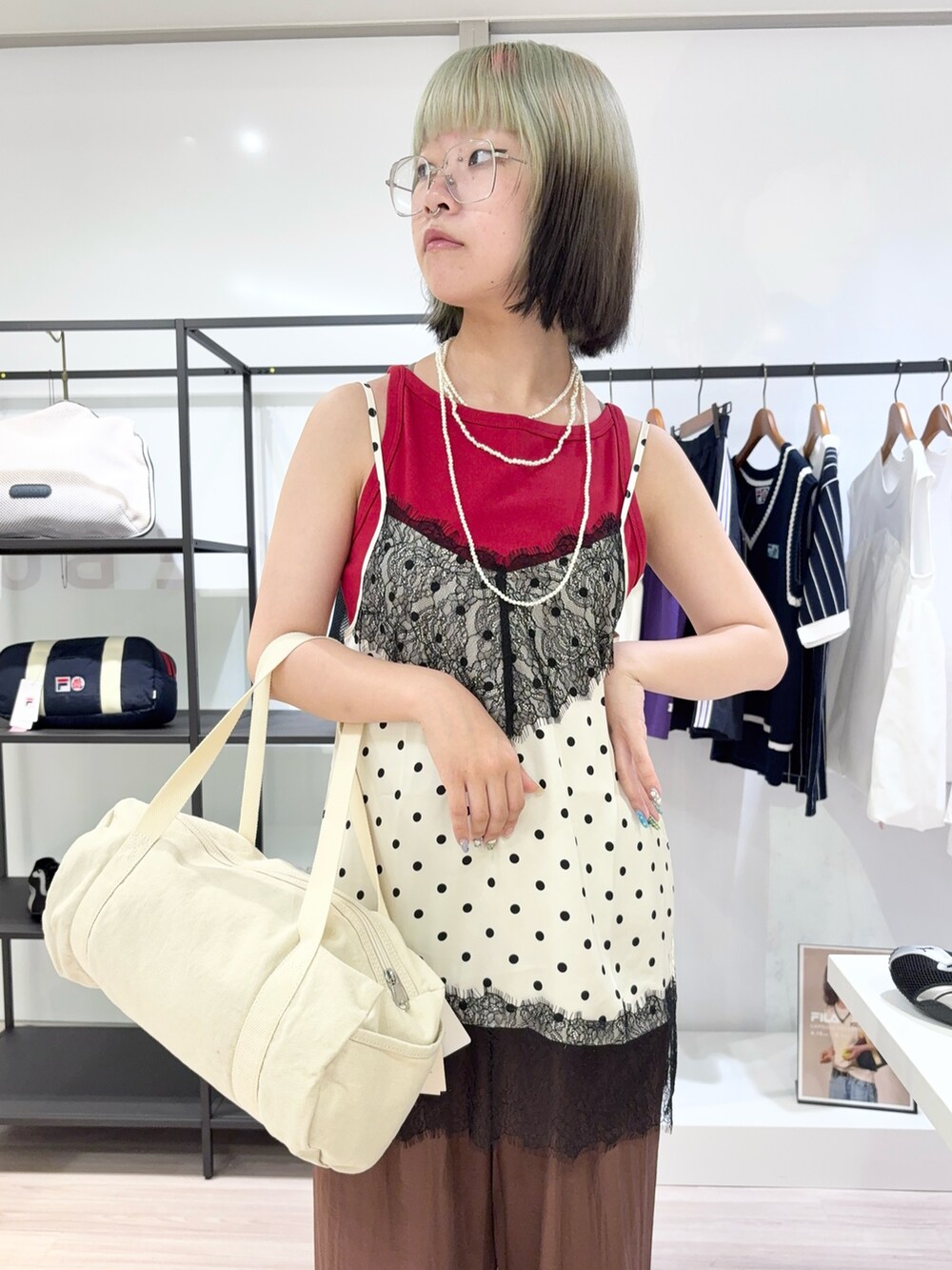 レッド系のタンクトップ、ブラウン系のその他パンツ、ホワイト系のボストンバッグを着用したレディースの夏コーディネートの5枚目の写真