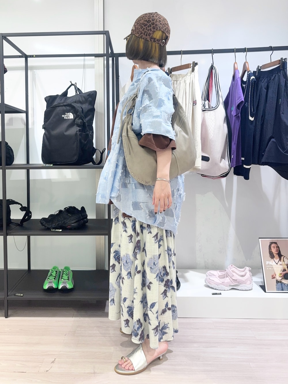 ブラウン系のTシャツ/カットソー、ホワイト系のスカート、ブラウン系のキャップを着用したレディースの春コーディネートの3枚目の写真