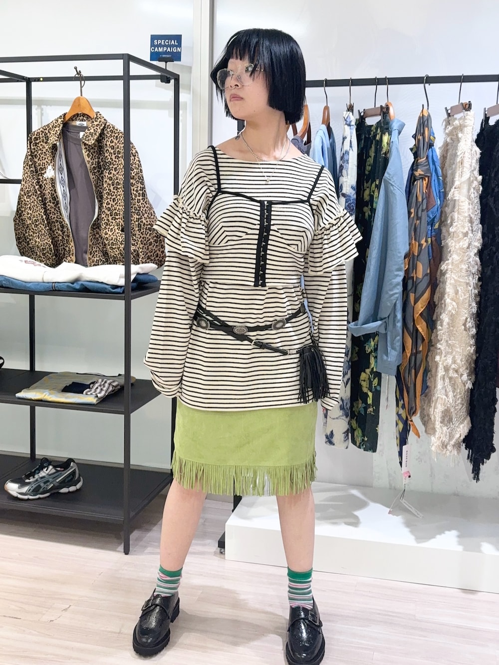 ホワイト系のキャミソール、ホワイト系のTシャツ/カットソー、グリーン系のスカートを着用したレディースの秋コーディネートの2枚目の写真