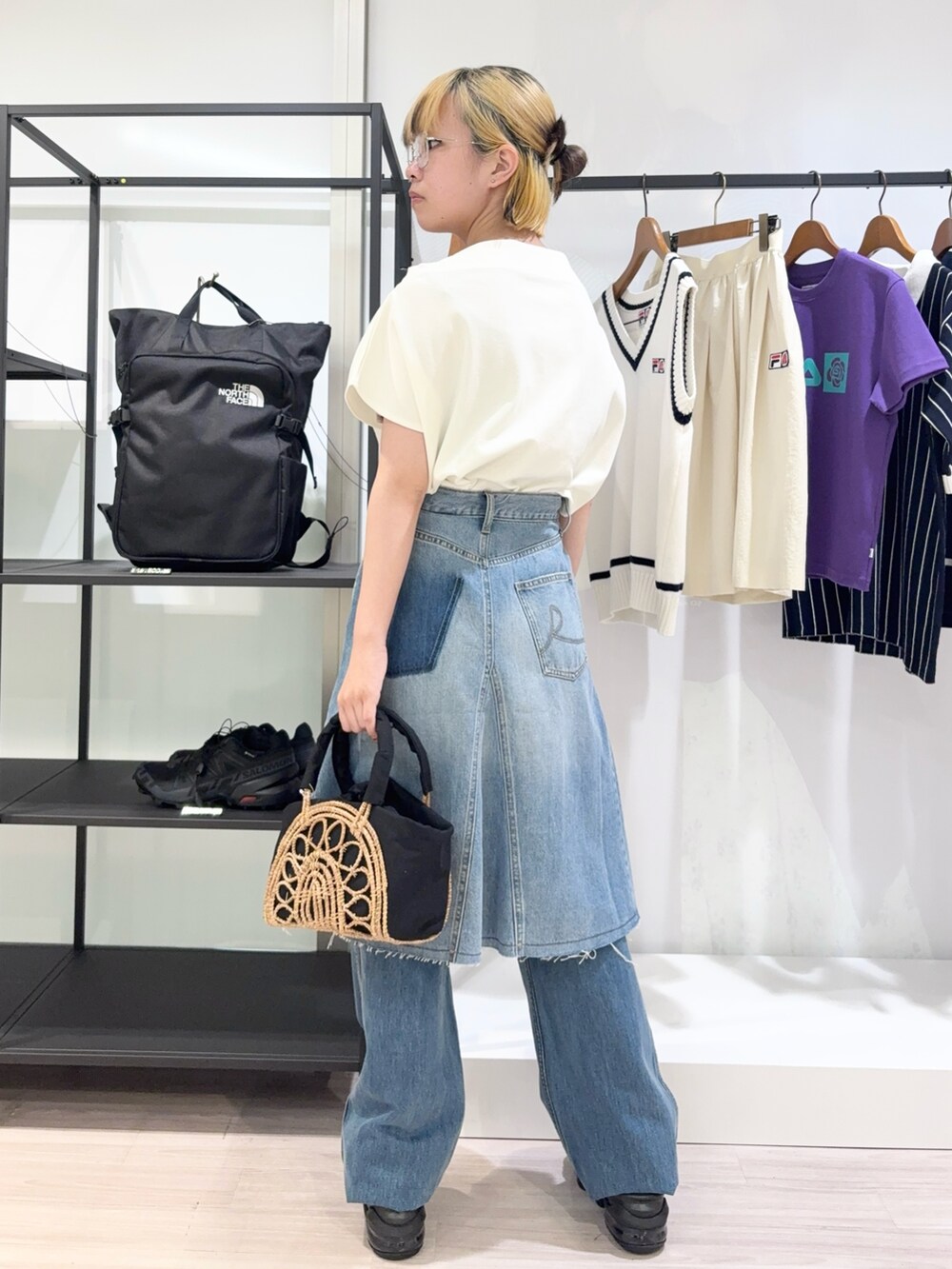 ブラック系のかごバッグ、ブルー系のデニムパンツ、ブラック系のサンダルを着用したレディースの夏コーディネートの3枚目の写真