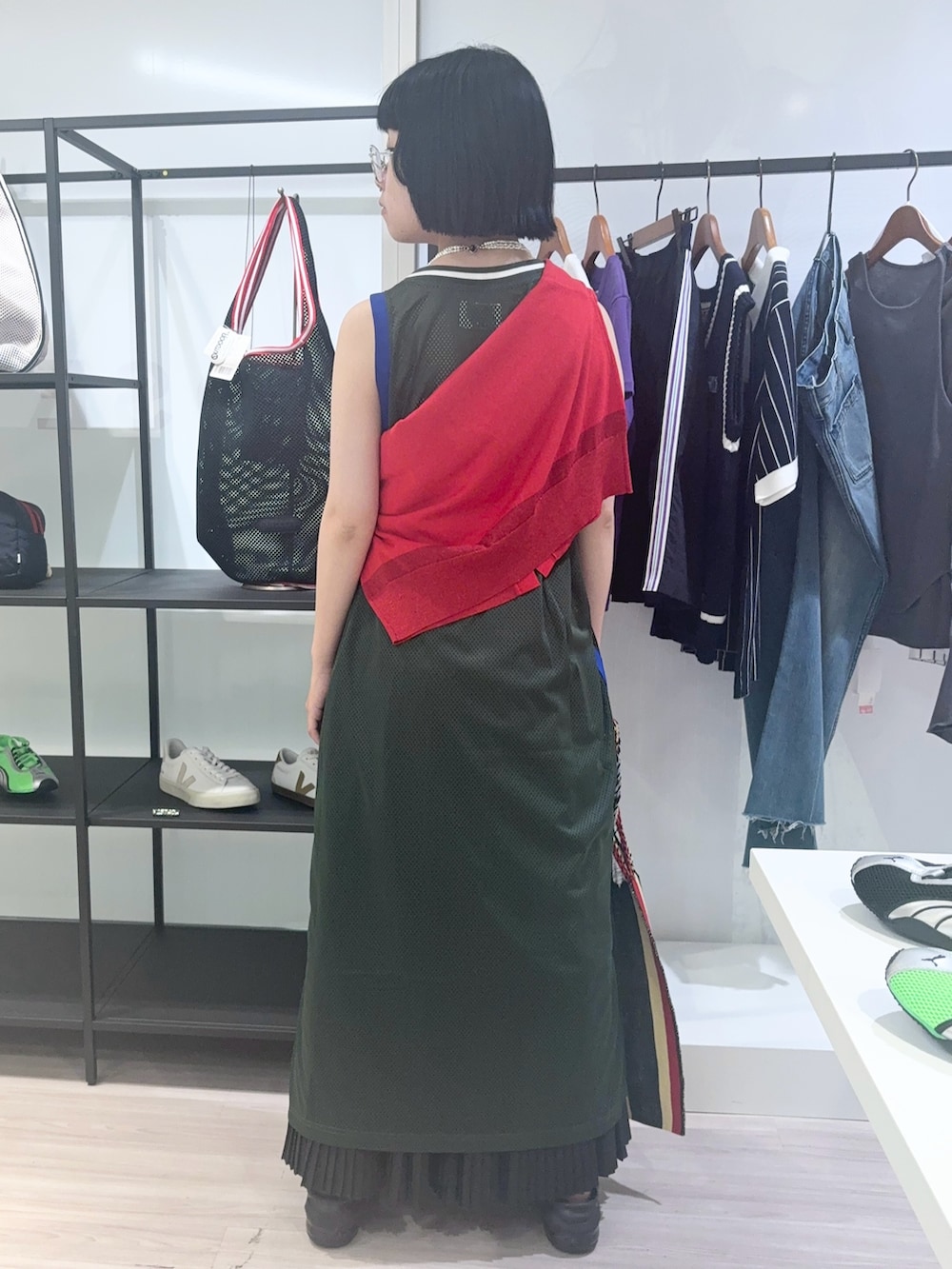 レッド系のニット/セーター、レッド系のショルダーバッグ、ブラック系のサンダルを着用したレディースの夏コーディネートの3枚目の写真