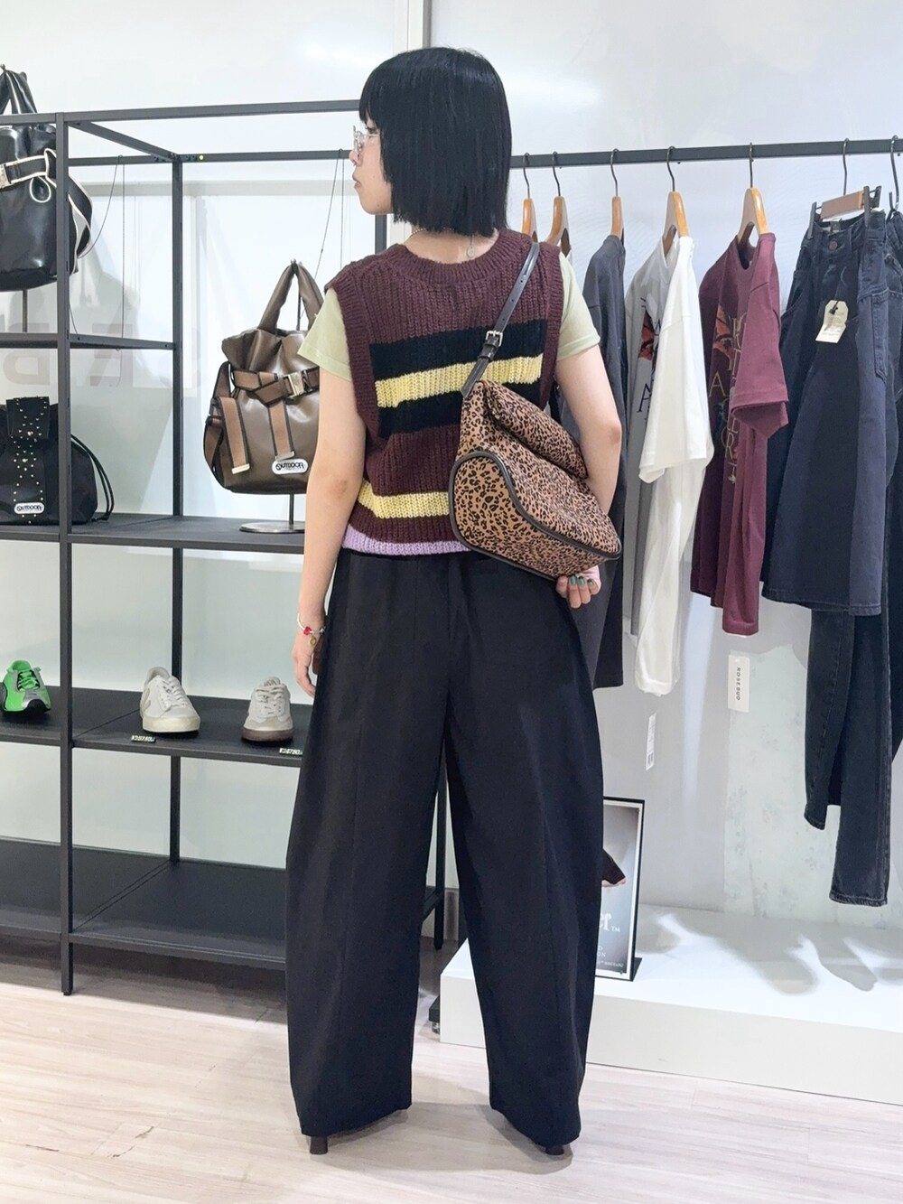 グリーン系のTシャツ/カットソー、ブラウン系のベスト、ブラック系のその他パンツを着用したレディースの秋コーディネートの4枚目の写真
