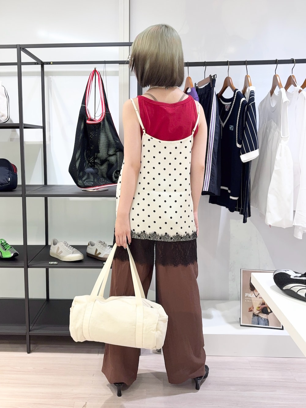 レッド系のタンクトップ、ブラウン系のその他パンツ、ホワイト系のボストンバッグを着用したレディースの夏コーディネートの4枚目の写真