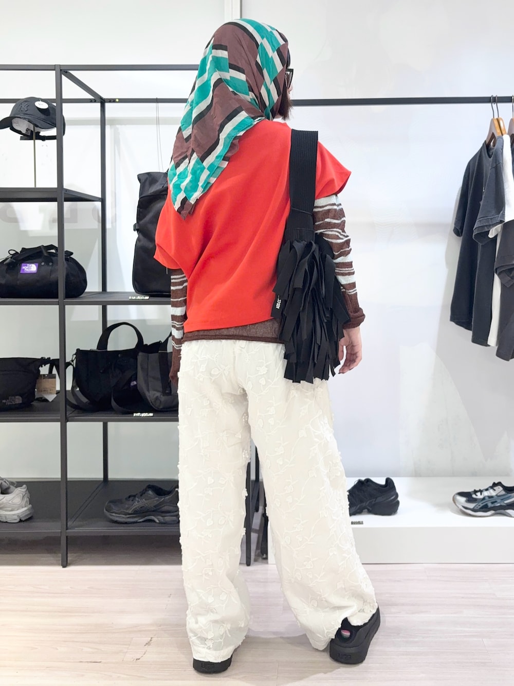レッド系のTシャツ/カットソー、ブルー系のカーディガン/ボレロ、ホワイト系のその他パンツを着用したレディースの春コーディネートの4枚目の写真