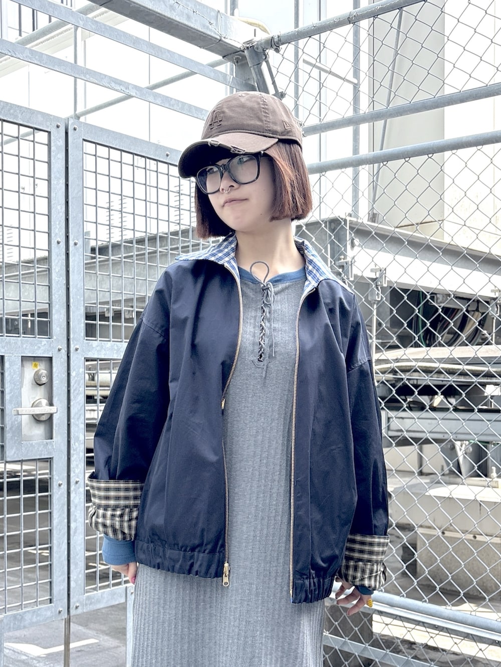 グレー系のワンピース、ブルー系のブルゾン、ホワイト系のスニーカーを着用したレディースの春コーディネートの7枚目の写真