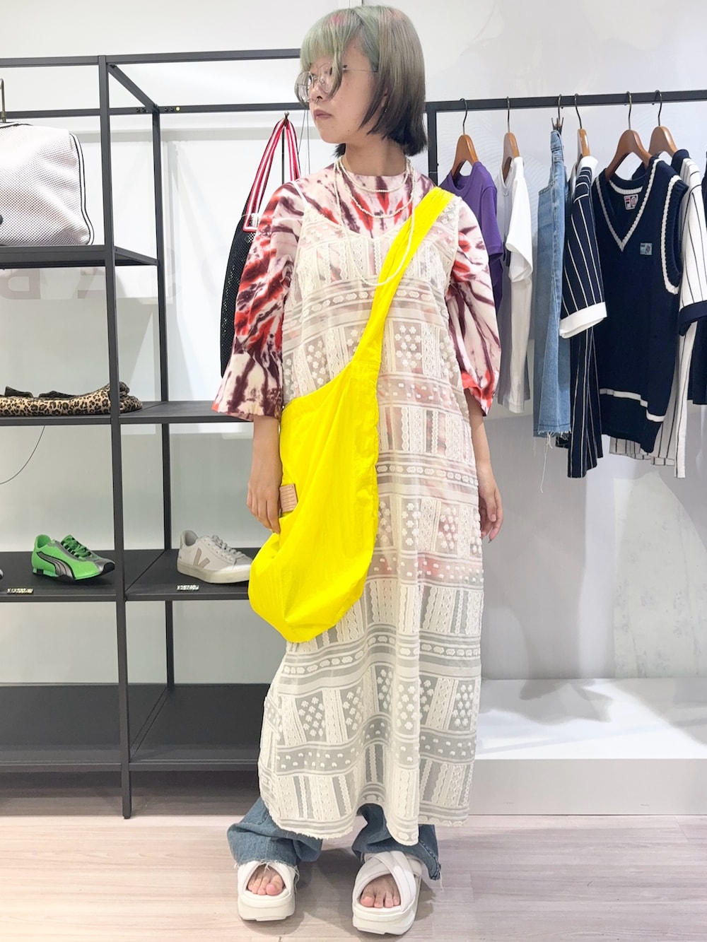レッド系のTシャツ/カットソー、ホワイト系のワンピース、ブルー系のデニムパンツを着用したレディースの夏コーディネートの2枚目の写真