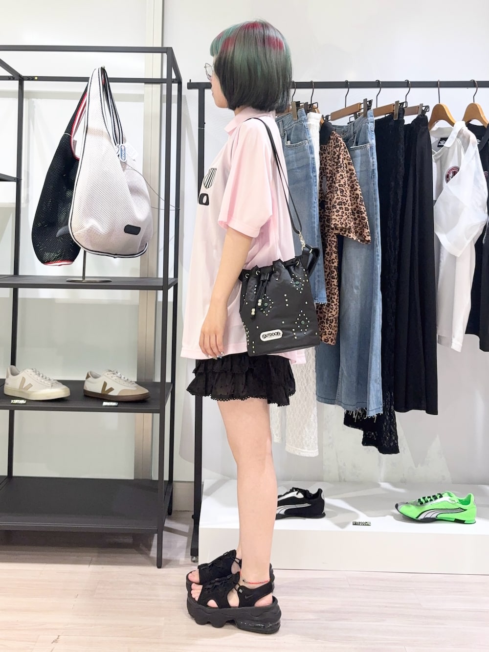 ブラック系のショルダーバッグ、ピンク系のTシャツ/カットソー、ブラック系のサンダルを着用したレディースの夏コーディネートの3枚目の写真