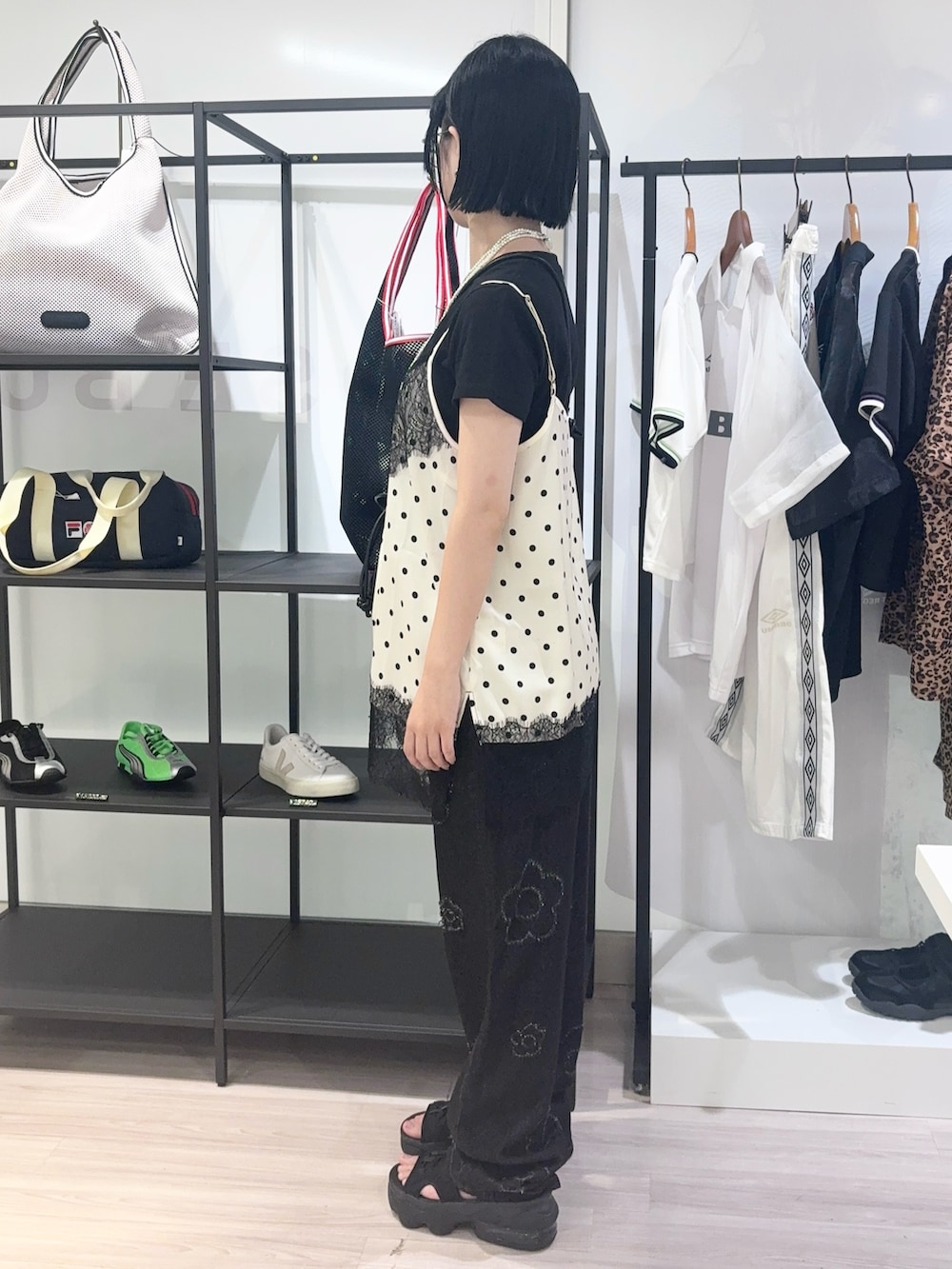 ホワイト系のキャミソール、ブラック系のサンダル、ブラック系のデニムパンツを着用したレディースの夏コーディネートの3枚目の写真